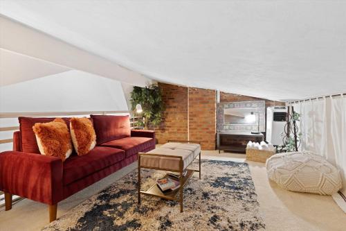 a living room with a red couch and a brick wall at Chic 1-BR Loft Nestled Between Dupont & Logan in Washington, D.C.