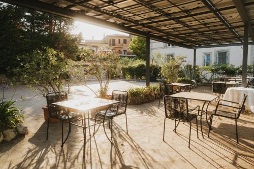 a patio with tables and chairs under a roof at Villa Clodia Relais in Manziana