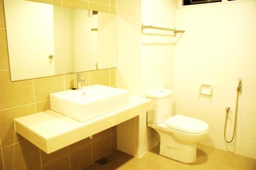 a bathroom with a sink and a toilet and a mirror at Shamrock Seaview 11 Villa in Batu Ferringhi