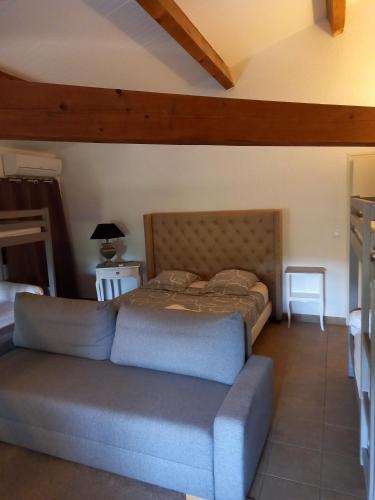 a bedroom with a bed and a couch at Escale au Salagou in Le Bosc