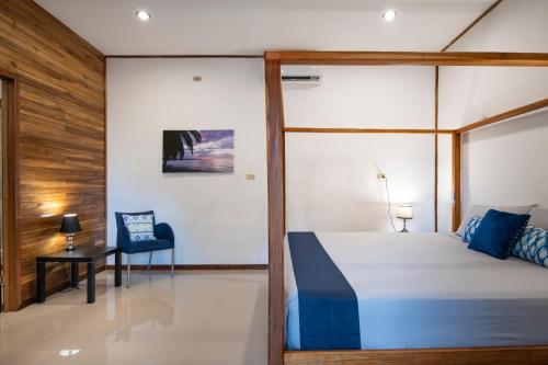 a bedroom with a bed and a desk and a chair at Pangea Lodge with Shared Pool at the Heart of Manzanillo in Manzanillo