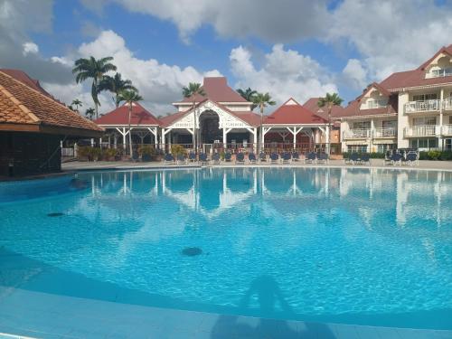 a large swimming pool in front of a resort at T3 Rhum Passion vue mer et rocher du Diamant dans célèbre Village de Vacances in Sainte-Luce