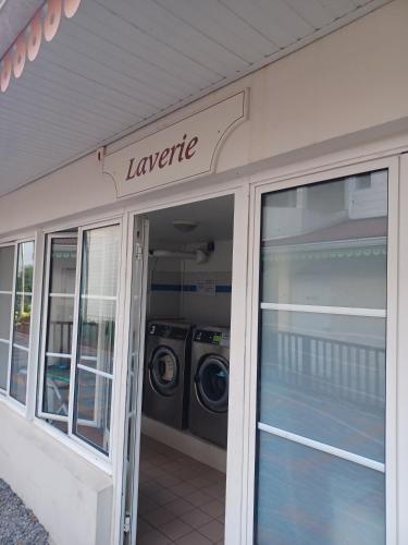 a laundry room with a washer and dryer inside of a building at T3 Rhum Passion vue mer et rocher du Diamant dans célèbre Village de Vacances in Sainte-Luce