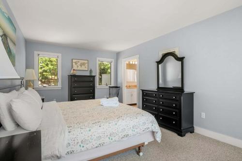 a bedroom with a bed and a dresser and a mirror at Beautifully Renovated w Access to Beach in Chatham