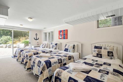 a group of four beds in a room at Beautifully Renovated w Access to Beach in Chatham
