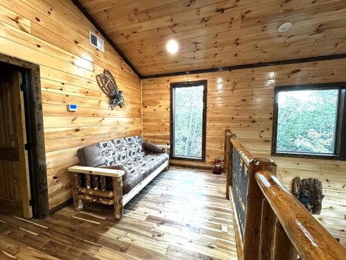 a living room with a couch in a log cabin at Lux Cabin Indoor and Outdoor Living in Sevierville