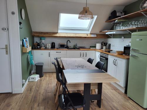La cuisine est équipée d'une table en bois et d'un réfrigérateur vert. dans l'établissement Chez SWAZ - T3 cosy 300m plage, à Berck-sur-Mer