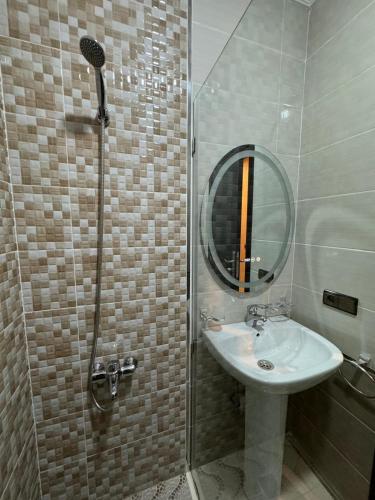 a bathroom with a sink and a shower with a mirror at Appartmojonera 306 in Beni Touzine