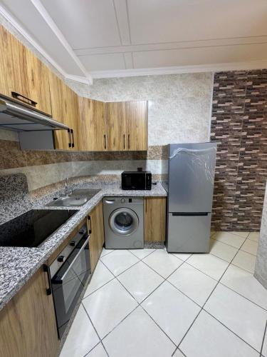 a kitchen with a stainless steel refrigerator and a dishwasher at Appartmojonera 306 in Beni Touzine