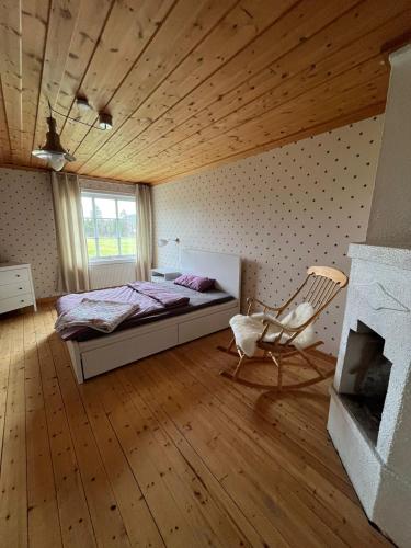 a bedroom with a bed and a chair and a fireplace at Room Svea in Arvidsjaur