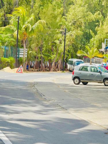 a car driving down a street with palm trees at Coquilles D'Argent Apart in Flic-en-Flac