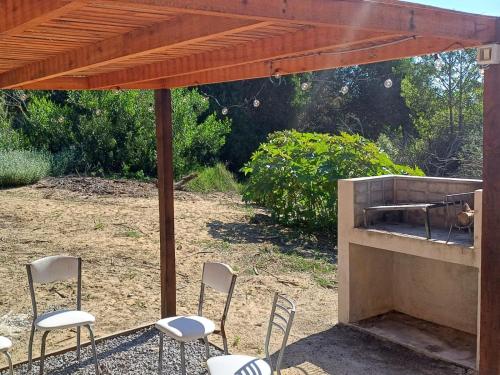 a patio with chairs and an outdoor grill at LOBOS DEL BOSQUE CON JACUZZi in Punta Del Diablo