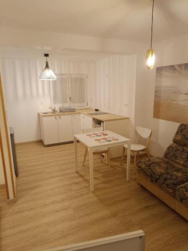 a living room with a table and a kitchen at La Pause in Soultz-Haut-Rhin