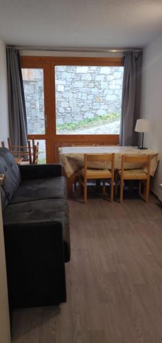 un salon avec une table et un canapé dans l'établissement T2 Plagne Villages skis au pied 32m2 très bien équipé, à Plagne Villages