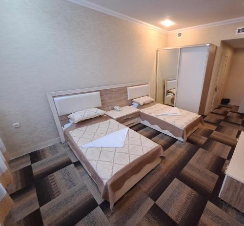 a room with two beds and a mirror at Arena Hotel Khachmaz in Xaçmaz