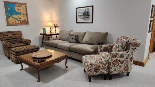 a living room with a couch and a chair at Woods Way Hideaway - minutes from Petoskey & Harbor Springs - close to beaches, skiing & more! in Petoskey