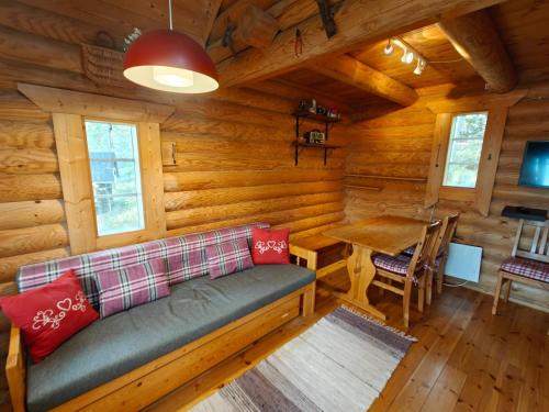 un soggiorno con divano in una baita di tronchi di Willa Axe a Hurissalo