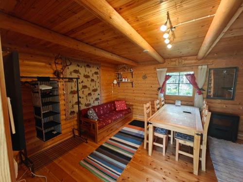 una sala da pranzo con tavolo e divano in una cabina di Willa Axe a Hurissalo