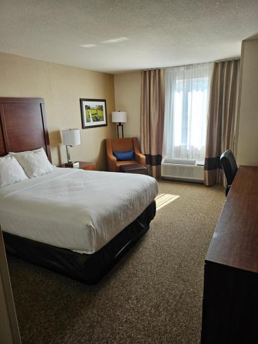 a hotel room with a bed and a chair at Comfort Inn & Suites in Goderich