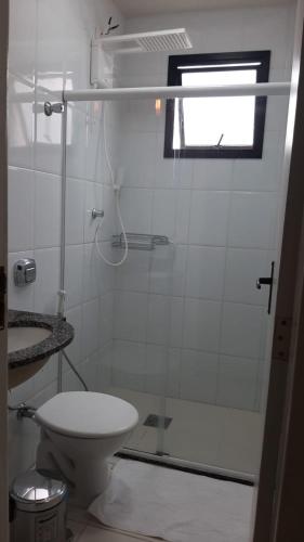 a white bathroom with a shower and a toilet at MELHOR ESCOLHA - 90 metros da Beira Mar - 2 Quartos com AR CONDICIONADOS SPLIT, Air Fryer, Wi-Fi, Disney Plus, Star Plus, HBO Max, Cadeiras de Praia, Caixa Térmica - 7 pessoas - Perto de tudo! in Guarapari