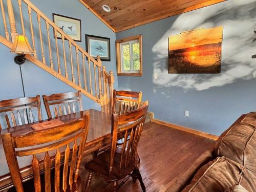 a dining room with a table and a couch at Beautiful Retreat on Sand Lake in Irons