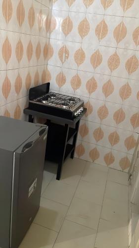 a stove in a kitchen with a wall at Keur Massar Tolou Laye WADE in Niadyorane