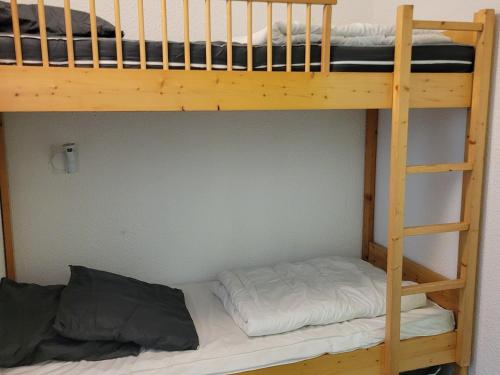un lit superposé avec une échelle à côté d'un lit superposé oublethritisthritisthritisthrite dans l'établissement Studio cabine proche centre station avec balcon, WiFi gratuit - FR-1-346-423, à Arc 1800