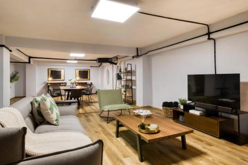 a living room with a couch and a flat screen tv at ULIV Apartments El Ángel in Mexico City