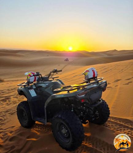a atv in the desert with the sunset in the background at Morocco wonderland in Merzouga