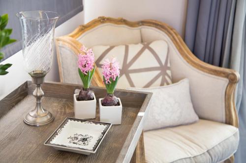 a table with two vases with flowers and a chair at The Y Hotel in Athens