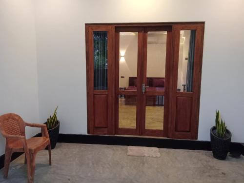 a wooden door in a room with a chair and plants at The Nest in Weligama