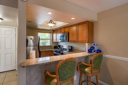 a kitchen with a counter with chairs and a refrigerator at FantasyWorld Resort in Kissimmee
