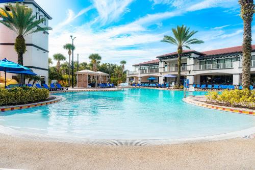 a large swimming pool at a resort with palm trees at FantasyWorld Resort in Kissimmee