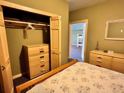 a bedroom with a bed and a dresser at Beautiful Retreat on Sand Lake in Irons