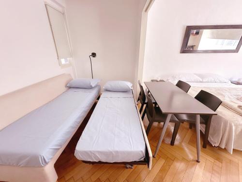 a room with a bed and a table and a bed and a couch at Amplio monoambiente en Microcentro in Buenos Aires