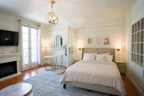 a bedroom with a large bed and a fireplace at Chambre de Bonne in Downtown Long Beach in Long Beach