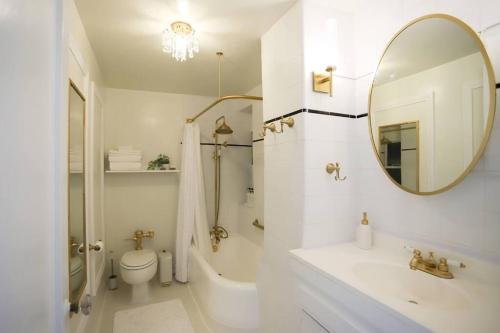 a bathroom with a sink and a toilet and a mirror at Chambre de Bonne in Downtown Long Beach in Long Beach