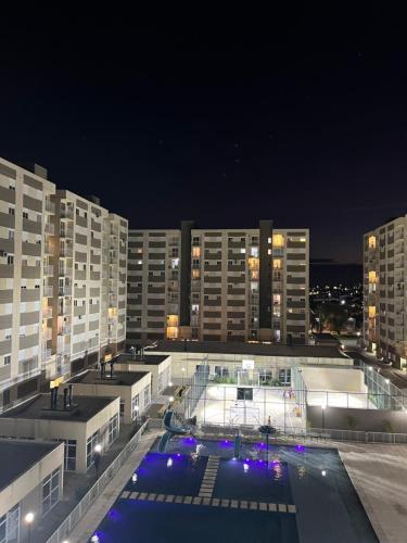 a large building with a pool at night at Apartamento novo Acqua Park in Pelotas