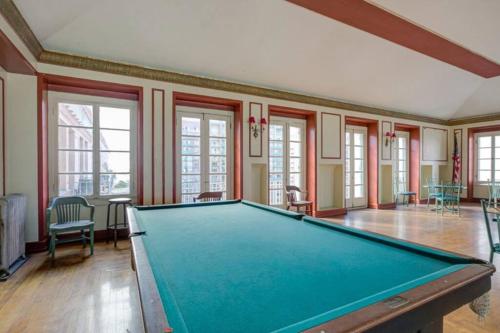 a pool table in a room with windows at Chambre de Bonne in Downtown Long Beach in Long Beach
