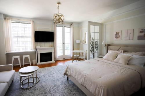 a bedroom with a white bed and a living room at Chambre de Bonne in Downtown Long Beach in Long Beach