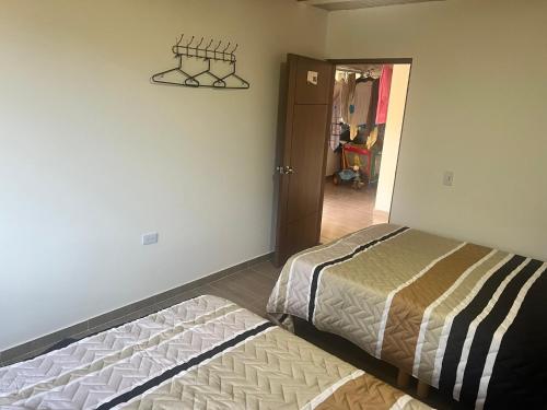 a bedroom with two beds and a door to a hallway at Quinta Las Mendoza in Zetaquira