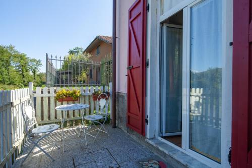 a patio with two chairs and a red door at Appartamento Perla in front of the Castle- Pool, wellness&Special Dinner in Tresana