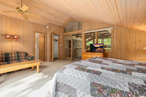 a bedroom with a bed and a tv in it at Causeway On Gull Resort in Lake Shore