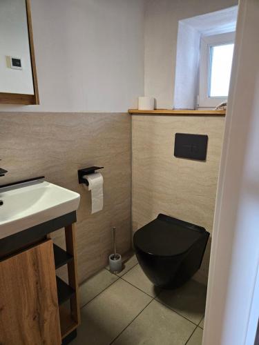 カーメンツにあるUnterkunft , Ferienwohnung auf dem Land, Monteurswohnungのバスルーム(黒いトイレ、シンク付)