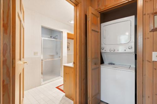 a kitchen with a refrigerator and a washer and dryer at Causeway On Gull Resort in Lake Shore