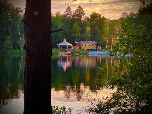 a house on a lake with a gazebo at Domaine Gagnon in Saint Sebastien