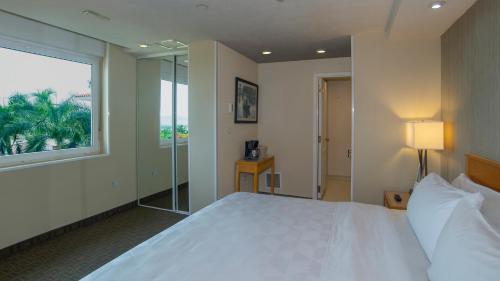 a bedroom with a large white bed and a window at Holiday Inn Cuernavaca by IHG in Cuernavaca