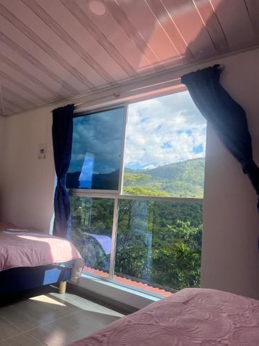 a bedroom with a large window with a view at Quinta Las Mendoza in Zetaquira