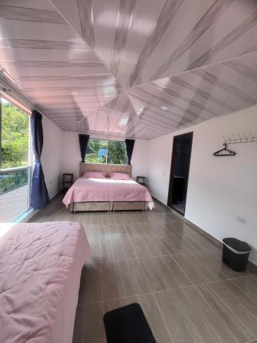 a bedroom with two beds and a ceiling at Quinta Las Mendoza in Zetaquira