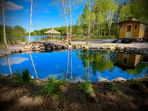 a view of a pond with a house in the background at Domaine Gagnon in Saint Sebastien